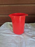 Full view of red plastic pitcher showing overall form