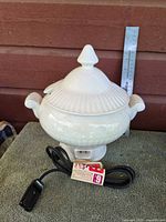 Overall view of porcelain electric heated tureen with lid, power cord, ruler for scale