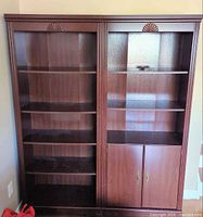Front view of empty two-section mahogany bookcase showing shelves and lower cabinet