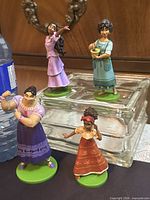 Front view of all four Encanto figures on glass block