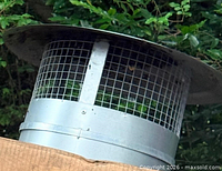 Side view of galvanized chimney cap resting on box