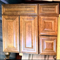 Front view of chestnut finish solid wood vanity cabinet with raised-panel doors and drawers
