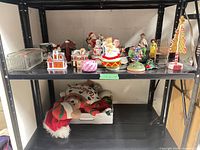 Full view of shelves with assorted holiday items including glass dish, figurines, metal sleigh, plush bear
