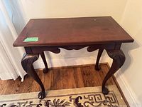 Front angled view of entire side table showing cabriole legs and scalloped apron