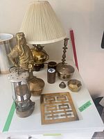 Overview of assorted brass, silver-tone and wood items on tabletop