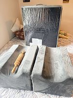 Pair of gray memory foam leg wedges with wooden massage roller and storage bag