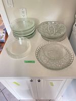 Overview of stacked pie plates, dinner plates, pressed glass platters