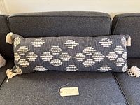 Full view of lumbar pillow on sofa showing size, color and overall condition