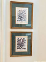 Both framed prints hanging side by side