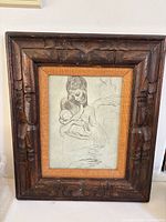 Full view of framed drawing showing carved wood frame and burlap liner