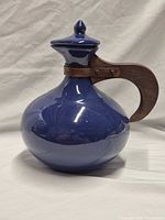 Full view of pitcher front, lid on, showing shape and glaze