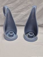 Front view of both light blue sculptural candle holders