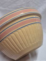 Side profile showing yellow ribbed body and pink/blue stripes
