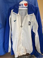Front view of white and blue Nike Brazil jacket hanging