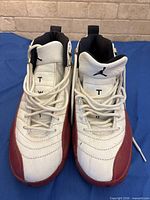 Top view of both shoes showing tongue embroidery, laces, leather condition