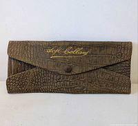 Front view showing crocodile embossing, gold script "soft collars" and snap closure