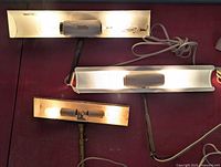 Three light fixtures lit to show operation