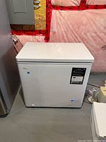 Front view of closed white chest freezer showing brand badge, info label and control panel