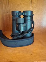 Full view of Nikon Monarch HG 8x42 binoculars with strap wrapped around base
