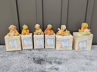 All six Cherished Teddies figurines lined up on their respective boxes