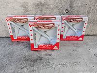 Three boxed Airbus A380 die-cast models side by side on concrete background