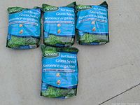 Front view showing four sealed Scotts Turf Builder Grass Seed bags