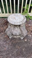 Top and front view of gray concrete pedestal with ornate detailing