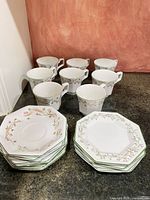 Full lot showing 8 cups, saucer stack, plate stack