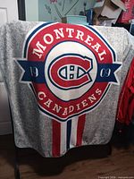 Front view of grey fleece throw displaying Montreal Canadiens crest