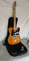 Full front view of guitar standing against included gig bag