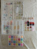 overview of five storage boxes with rhinestones, charms, pom-poms and tool
