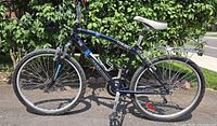 Left side view of Nakamura Tango mountain bike showing frame, wheels, suspension fork, saddle, rear rack, and handlebar accessories