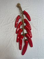 Full view of ceramic pepper hanging showing all peppers and rope