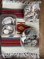 all three containers of shells and pebbles on textile