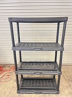 Front view of full four-shelf gray plastic shelving unit