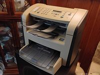 Three-quarter front view showing overall unit, control panel, paper output tray and input cassette