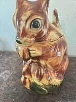 Front view of squirrel cookie jar showing hand-painted glaze and removable lid seam