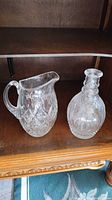 Pitcher and decanter side by side on shelf