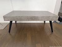 Full view of coffee table showing top, legs, flooring for scale