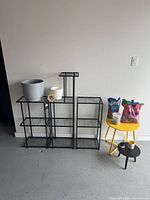 Overall view of black metal plant stands, planters, fertilizer and potting supplies