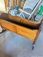 side view of wooden rocking cradle planter showing exterior finish and rocker base