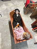 Cradle with both dolls inside showing overall lot