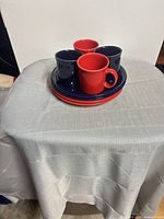 Stacked plates with four mugs on top showing color variety