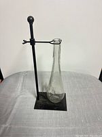 Full view of glass vase on metal stand