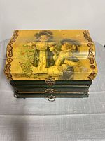 Front view of green wooden jewelry box showing decoupage lid and metal latch