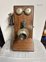 Front view showing wood case, brass bells, mouthpiece