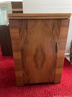 Closed view of wood cabinet side showing veneer pattern and handle
