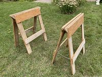 Both wooden folding sawhorses standing on lawn