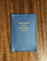 Front of closed blue wallet showing gold title text