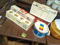 Shape sorter, barn and drum on table